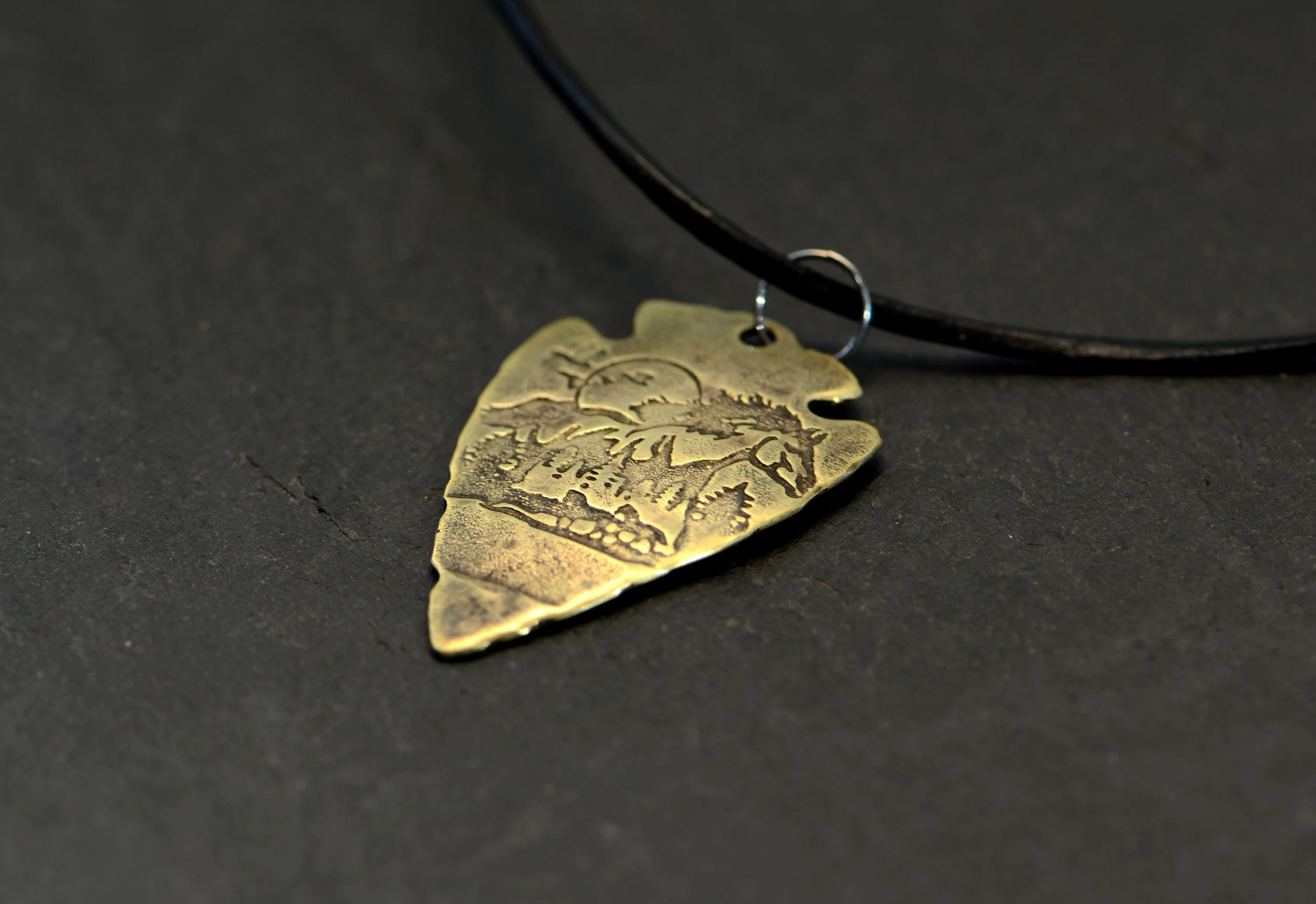 Bronze arrowhead necklace with horses and mountains